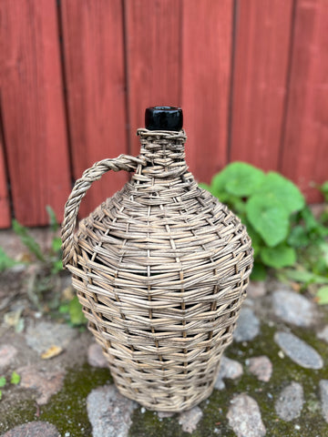 Damejeanne i flätad korg